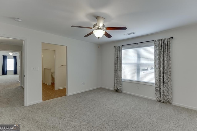 spare room with light colored carpet and ceiling fan