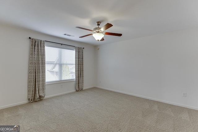 carpeted spare room with visible vents, ceiling fan, and baseboards