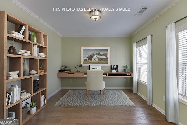 office with a wealth of natural light, visible vents, built in desk, and wood finished floors