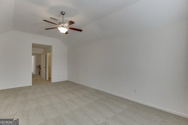 spare room featuring lofted ceiling, visible vents, carpet flooring, ceiling fan, and baseboards