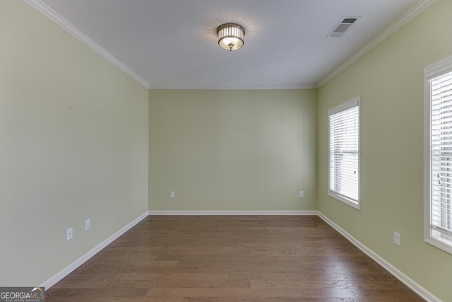 spare room with baseboards, crown molding, visible vents, and dark wood-style flooring