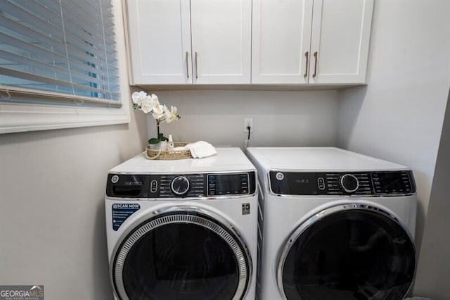 laundry area featuring washing machine and clothes dryer and cabinet space