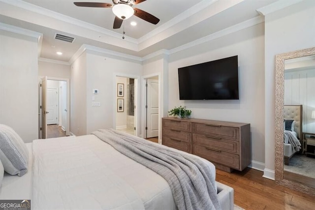 bedroom with wood finished floors, ornamental molding, recessed lighting, ceiling fan, and a raised ceiling