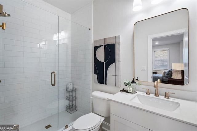 bathroom with a shower stall, vanity, and toilet