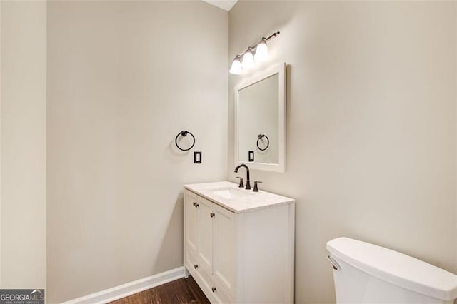 bathroom with vanity, hardwood / wood-style flooring, and toilet