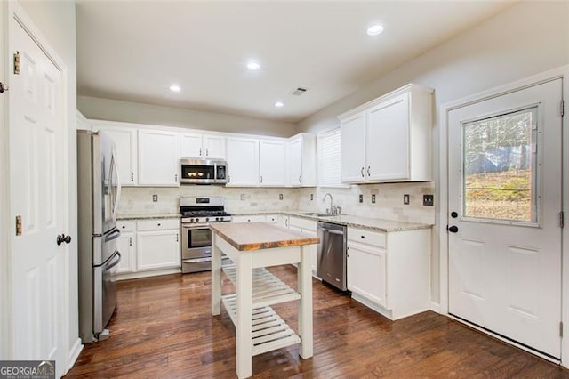 kitchen featuring stainless steel appliances, white cabinetry, and sink