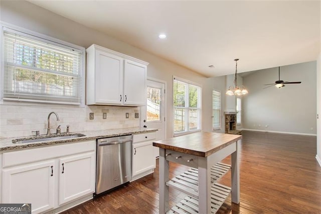 kitchen featuring sink, light stone counters, tasteful backsplash, stainless steel dishwasher, and white cabinets