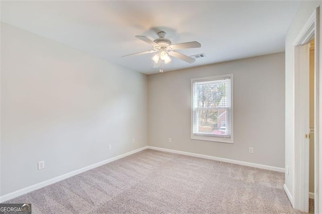 carpeted spare room featuring ceiling fan