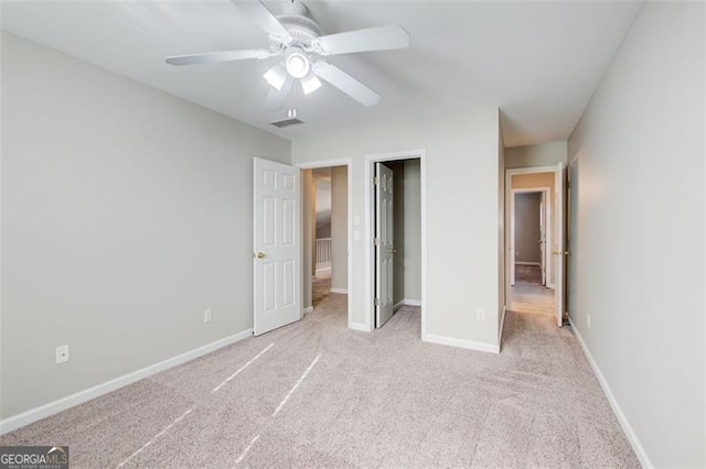 unfurnished bedroom with light colored carpet, ceiling fan, and a closet