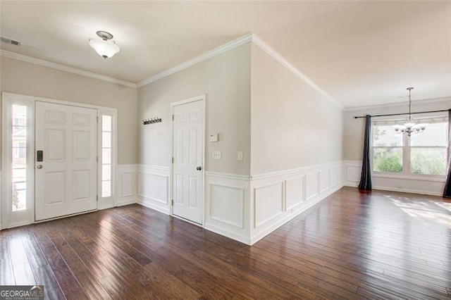 entryway with ornamental molding, dark hardwood / wood-style floors, and a notable chandelier