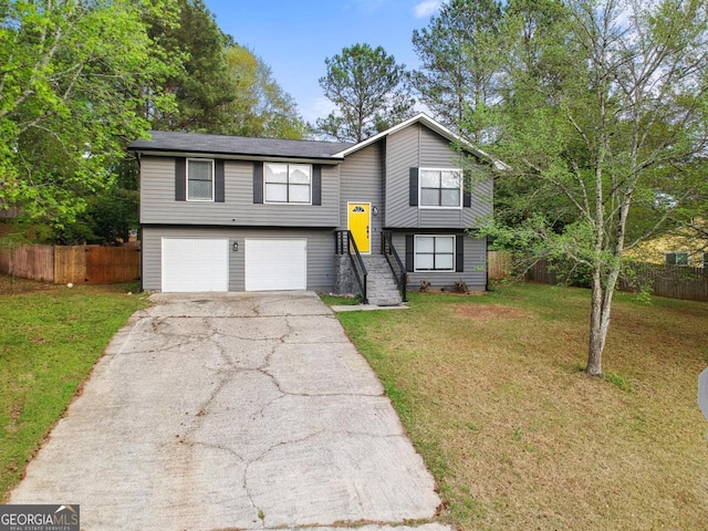 raised ranch featuring a garage and a front yard