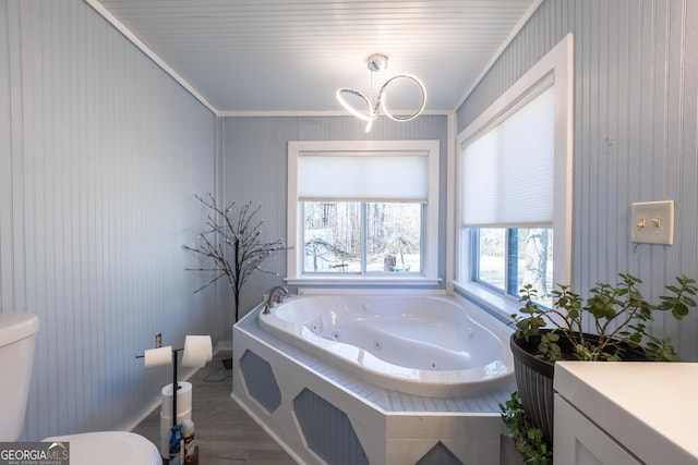 bathroom with a bathtub, ornamental molding, a chandelier, and toilet