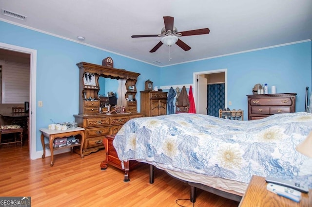 bedroom with ornamental molding, ceiling fan, and light wood-type flooring