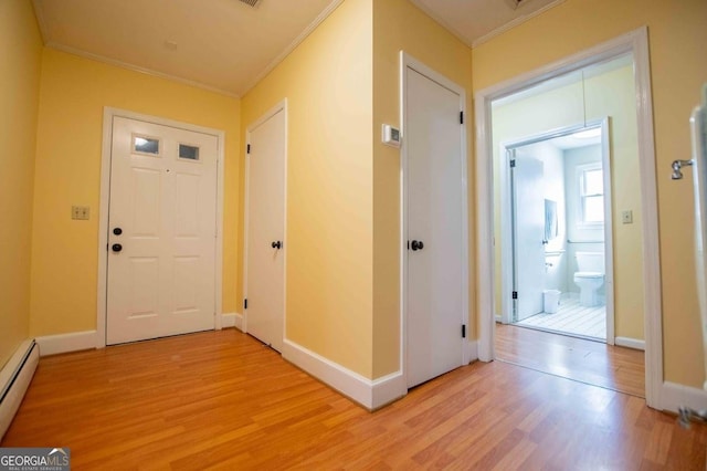 foyer featuring crown molding, light hardwood / wood-style flooring, and baseboard heating