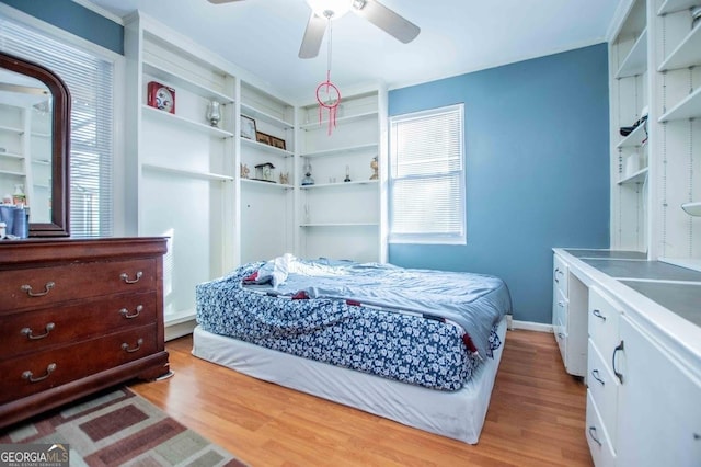 bedroom featuring ceiling fan, multiple windows, and light wood-type flooring