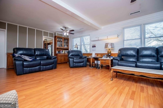 living room featuring beam ceiling, wood-type flooring, and ceiling fan