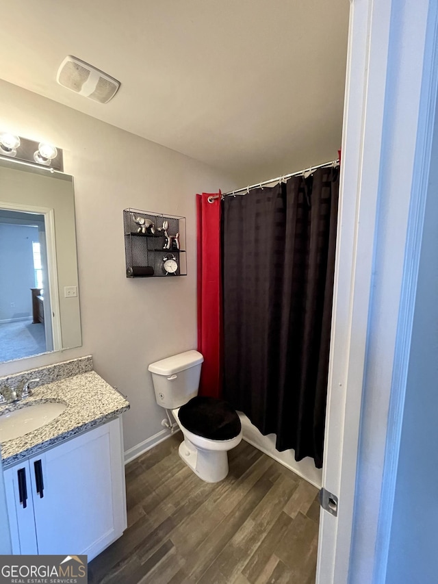 bathroom featuring hardwood / wood-style flooring, vanity, and toilet