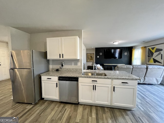 kitchen featuring appliances with stainless steel finishes, dark hardwood / wood-style floors, sink, and white cabinets