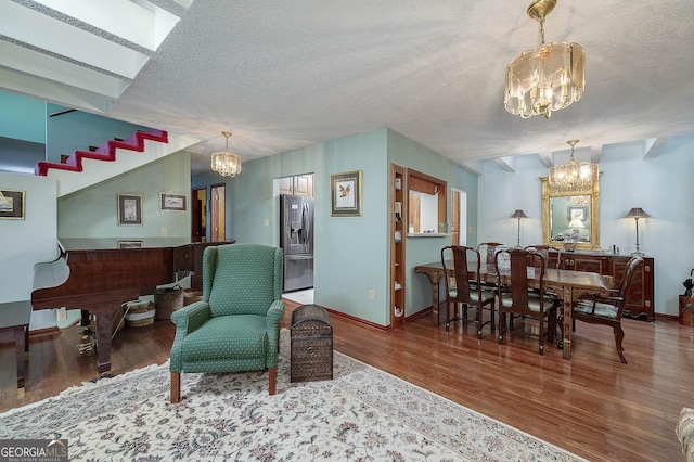 sitting room featuring wood-type flooring, a textured ceiling, and a notable chandelier