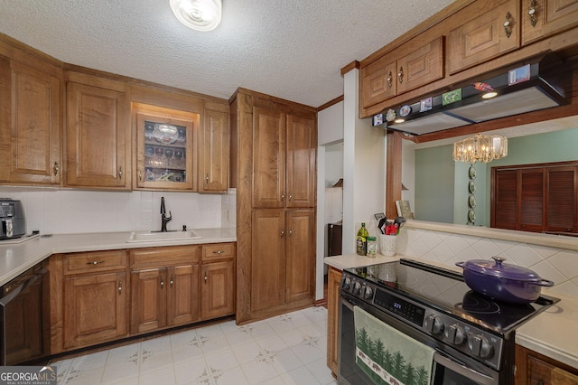 kitchen with electric stove, sink, hanging light fixtures, backsplash, and exhaust hood