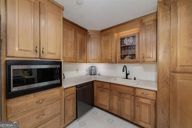 kitchen featuring tasteful backsplash, dishwasher, sink, and a textured ceiling