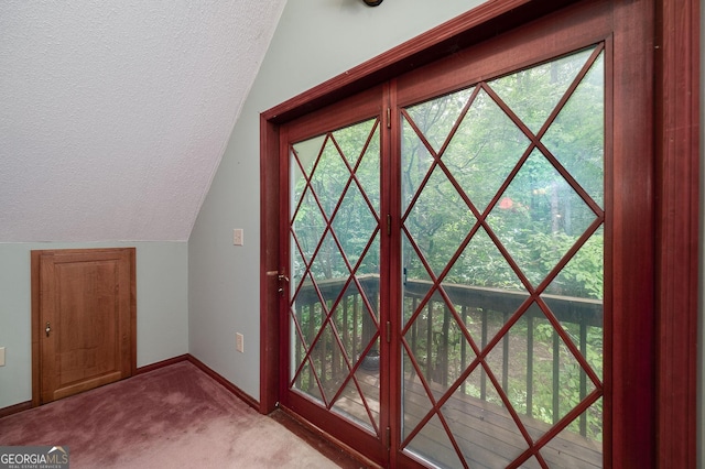 doorway to outside featuring vaulted ceiling, light colored carpet, and a textured ceiling