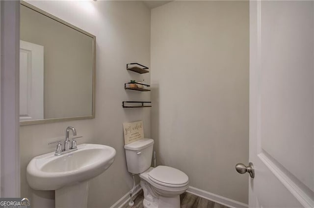 bathroom featuring hardwood / wood-style flooring, sink, and toilet