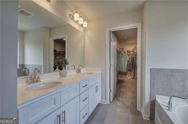 bathroom with vanity, a bath, and tile patterned floors