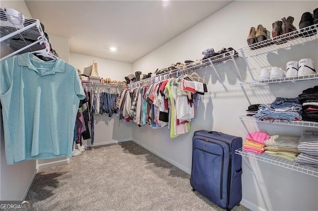 walk in closet with light colored carpet