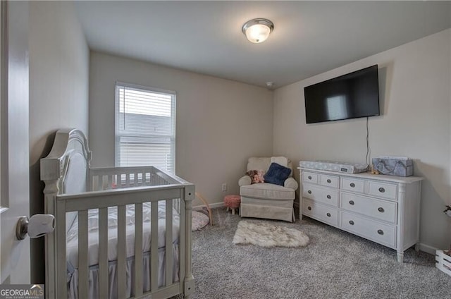 carpeted bedroom featuring a nursery area