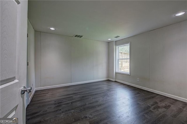 empty room with dark hardwood / wood-style flooring