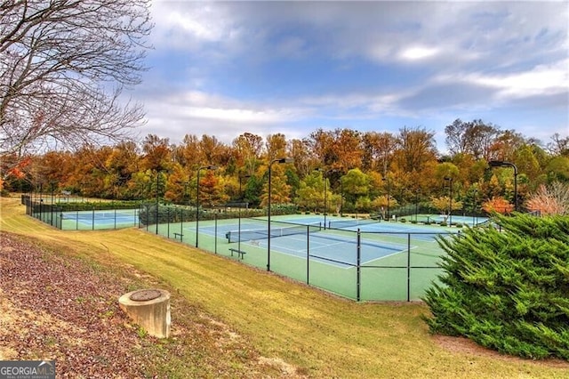 view of tennis court with a yard