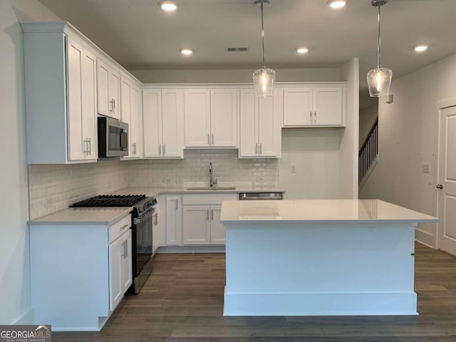 kitchen with white cabinetry, stainless steel appliances, and sink