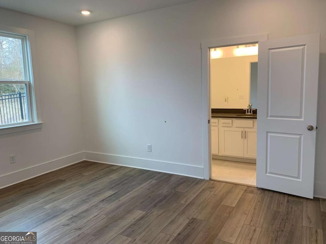 unfurnished room featuring hardwood / wood-style flooring and sink