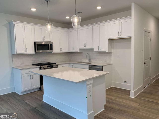 kitchen with a center island, appliances with stainless steel finishes, sink, and white cabinets