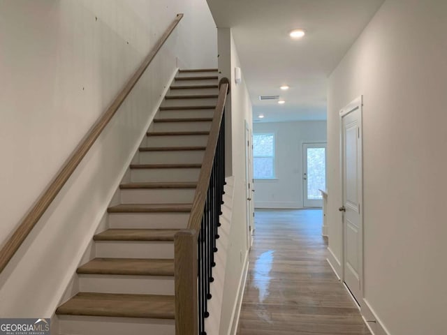 staircase with hardwood / wood-style floors