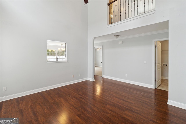 unfurnished living room with a high ceiling and dark hardwood / wood-style flooring