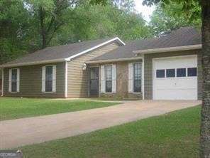 ranch-style house featuring a garage and a front yard