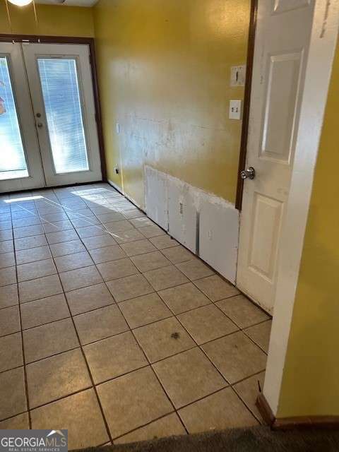 interior space with light tile patterned floors and french doors