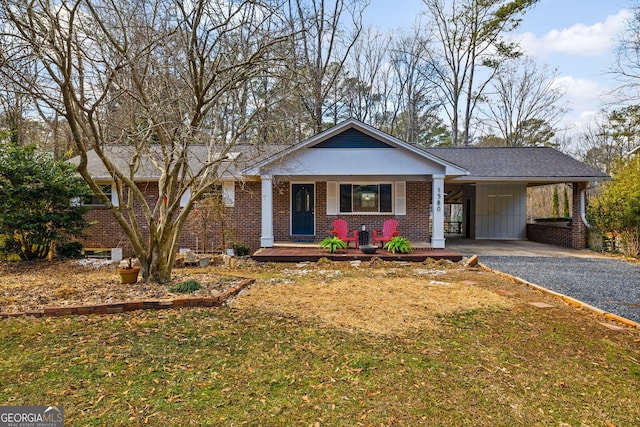 view of front facade with a front lawn, a carport, and covered porch