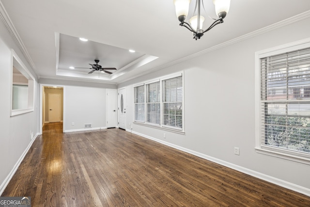 unfurnished living room with a raised ceiling, ornamental molding, dark wood-type flooring, and ceiling fan with notable chandelier