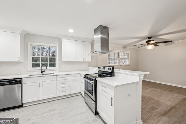 kitchen featuring island range hood, sink, white cabinets, kitchen peninsula, and stainless steel appliances