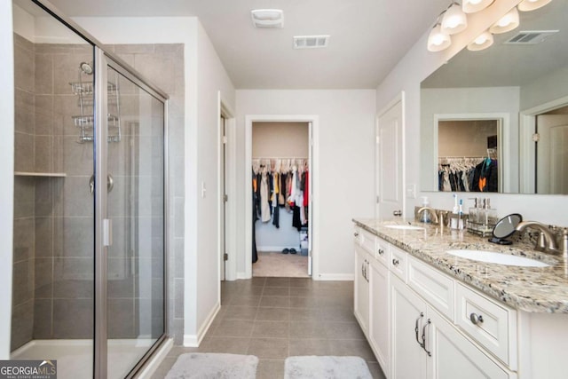 bathroom featuring vanity, a shower with door, and tile patterned flooring