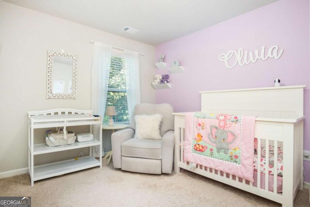 carpeted bedroom featuring a crib