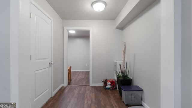 corridor with dark hardwood / wood-style flooring