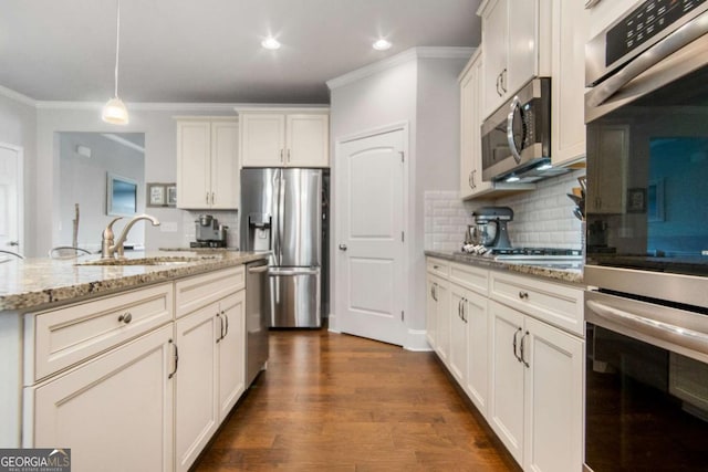 kitchen featuring sink, light stone counters, a center island with sink, pendant lighting, and stainless steel appliances