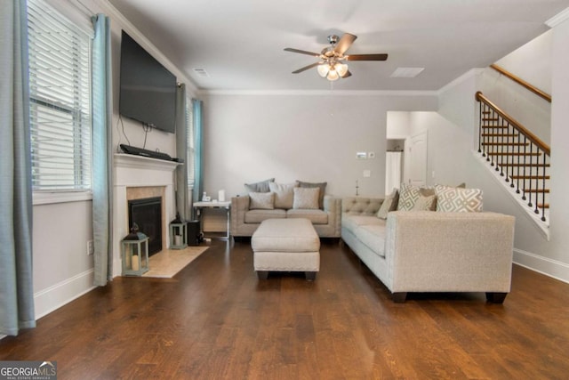 living room with ornamental molding, dark wood-type flooring, and ceiling fan