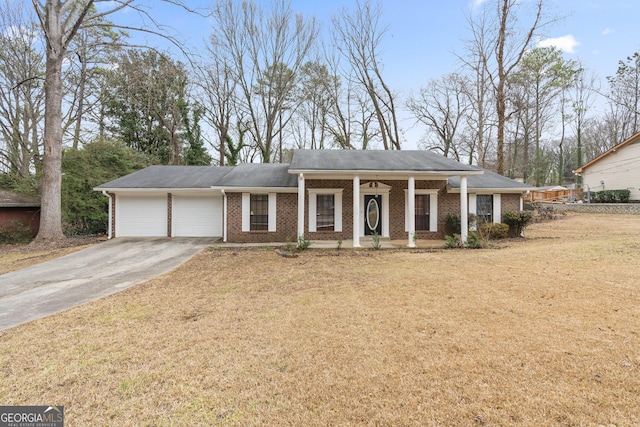 view of front of house featuring a garage, covered porch, and a front lawn