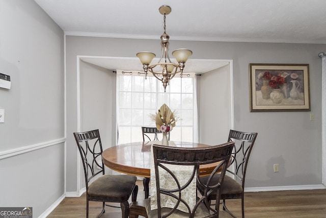 dining room with an inviting chandelier, crown molding, and dark hardwood / wood-style floors