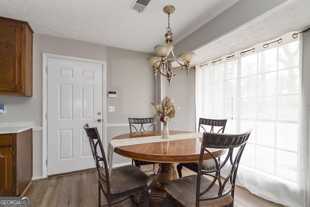 dining space featuring hardwood / wood-style flooring and a chandelier